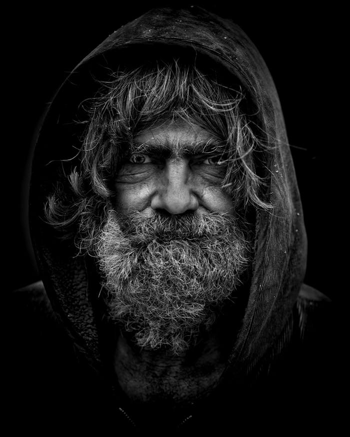 services-04 Emotive black and white portrait of an elderly man with a rugged appearance.